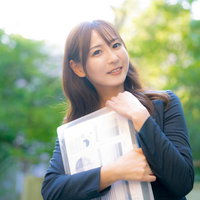 奇遇ですね！わたしも今からオフィスに戻るところです。書類を抱えた笑顔の女性の写真