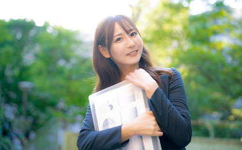 奇遇ですね！わたしも今からオフィスに戻るところです。書類を抱えた笑顔の女性