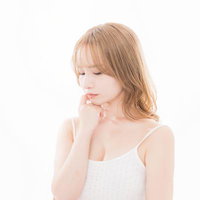 顔に手を当てて考え込む美容系モデルのビューティーの写真