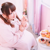 ピンクのドレスでマカロン美味しぃ♡ツインテールの女性がスイーツを堪能の写真