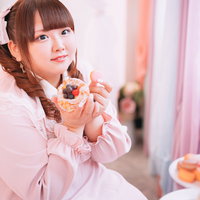 ピンクのマカロンを両手でもつゆるふわツインテ女子の写真