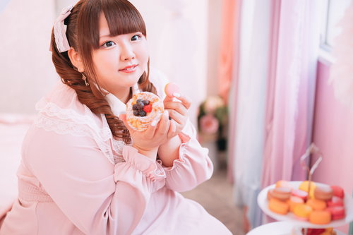 ピンクのマカロンを両手でもつゆるふわツインテ女子