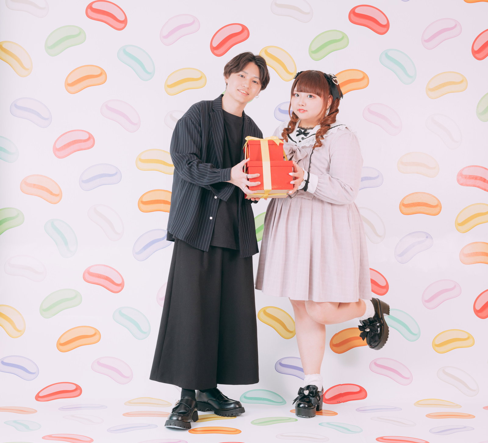 赤いプレゼントを持って笑顔のぽっちゃりカップル［モデル：あづき SHUN］