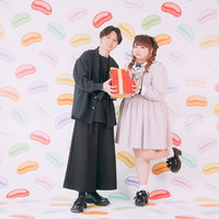 プレゼントを持ったぽっちゃりカップルのハッピーな記念日の写真