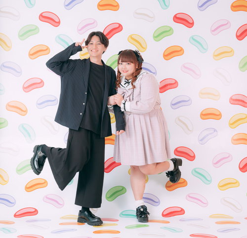 彼氏とツインテぽっちゃり女子がカラフルな背景で笑顔