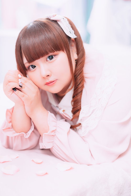 ピンクのフリルブラウスを着たこちらを見つめるぽちゃかわ女子