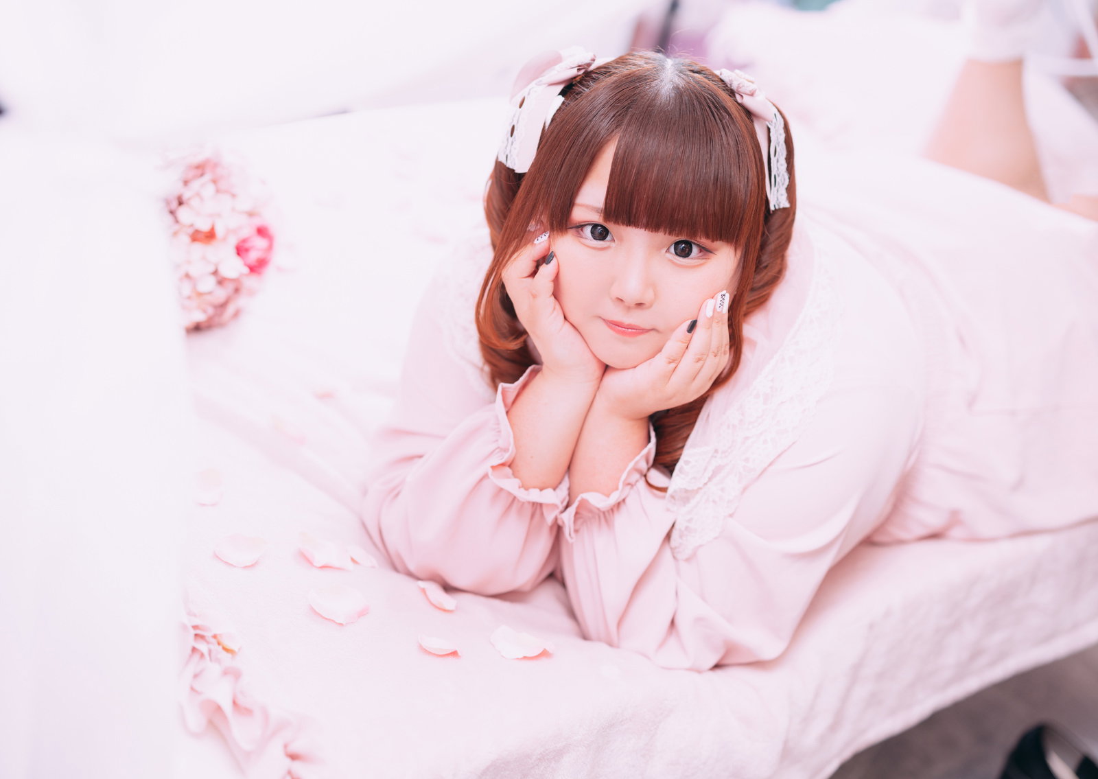 ピンク色のふわふわ衣装でツインテールの女性が歯痛のポーズをしている［モデル：あづき］