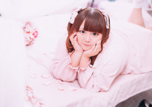 ピンクのふわふわ衣装でツインテールの歯痛ポーズをするぽちゃかわ女子