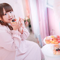 ピンクの甘ロリータ服でタルトとマカロンを食べるぽちゃかわ女子の写真
