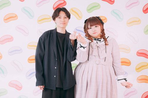 ピンク背景で指でハートを作る若いカップル