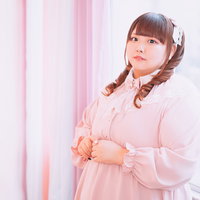 窓際のピンク衣装でツインテール姿のぽちゃかわアイドルの写真