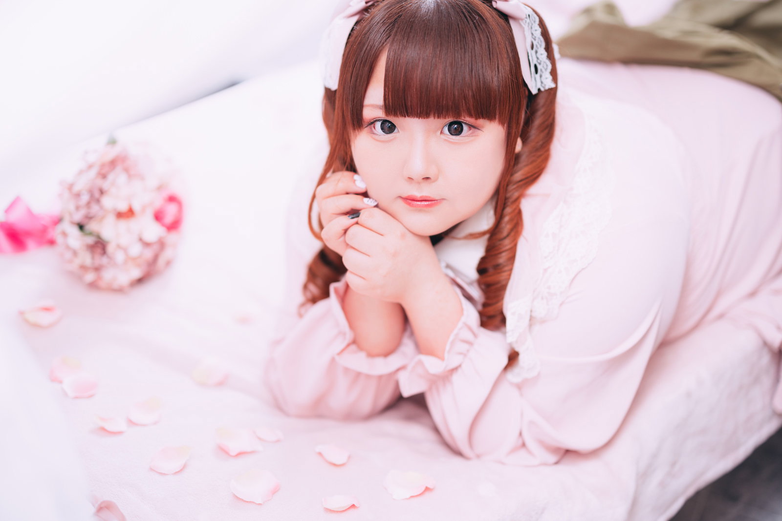 ツインテール姿のぽっちゃり女性がピンク衣装でカメラを見つめている［モデル：あづき］