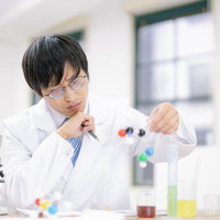 実験器具を使って分子構造モデルで研究する科学者の写真