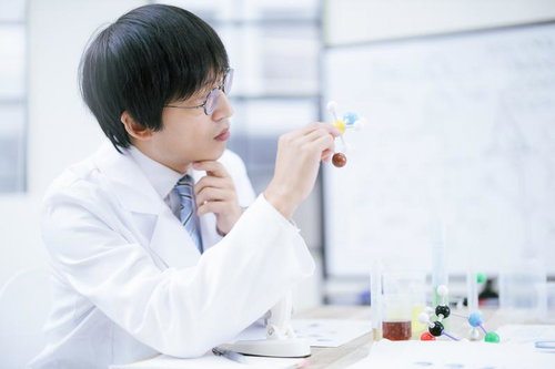 分子構造モデルを手に取りながら考え込む男性研究者