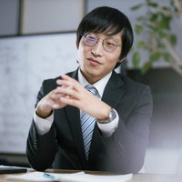 コンサルタント風の男性がオフィスで説明するの写真