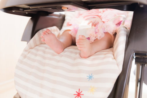 ベビーチェアに座る赤ちゃんのムチムチあんよ