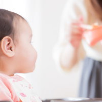 離乳食に熱い視線を送る赤ん坊の写真