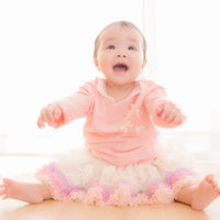 駄々をこねる姿も可愛い乳幼児のピンク服姿の写真