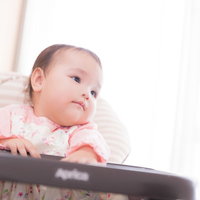 クッションに寄りかかるベビーの笑顔の写真