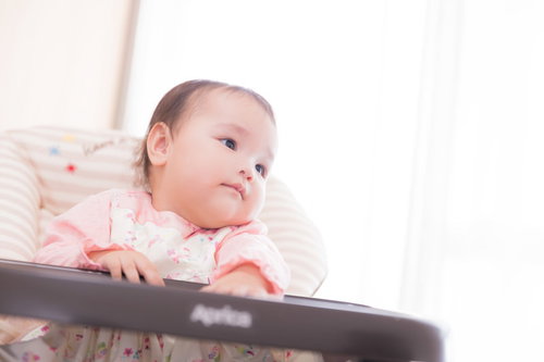 クッションに寄りかかるベビーの笑顔