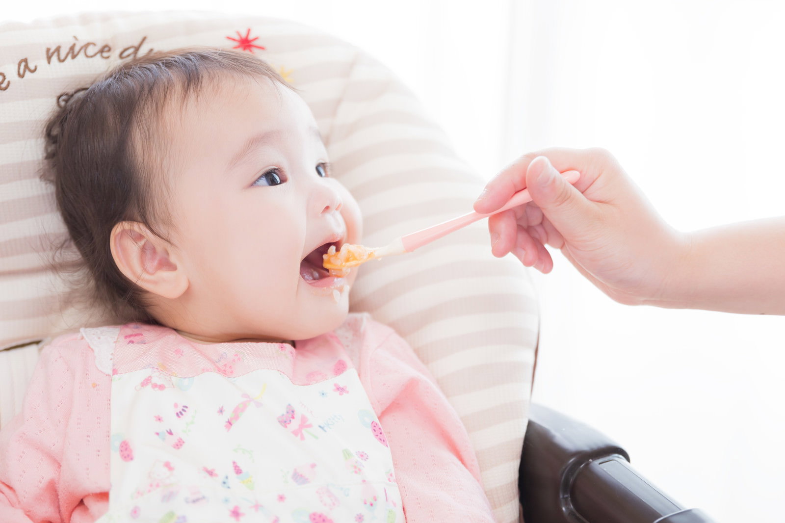 大きなお口をあけて離乳食を食べる赤ちゃん［モデル：めぐな］