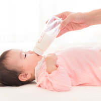 哺乳瓶でミルクを飲んで泣き止む赤ちゃんの育児シーンの写真