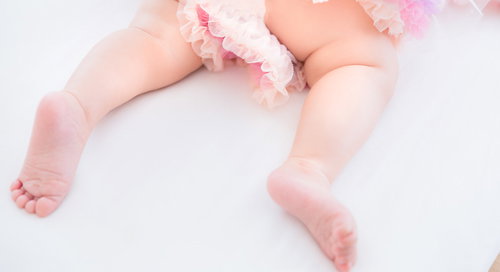 ピンク色のオムツを着用した乳幼児のムチムチな足