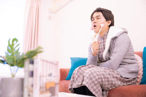 小顔ローラーでセルフケアをする男性の美容ケア