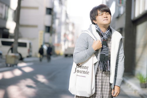 これから買い物におでかけする陽気な男性が街中を歩く