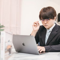 ワークスペースで業務中の会社員のデスクワークの写真