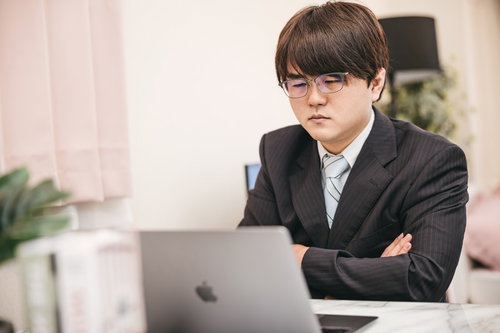 数字とにらめっこして腕を組む経理担当者の困った表情