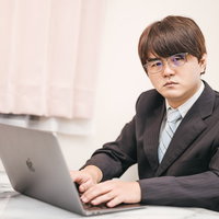 そのやり方には疑問を感じますね、デスクワーク中の男性会社員の写真