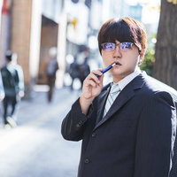 「ここで煙草は吸わないでもらえますか」と言われて不機嫌そうな会社員の写真