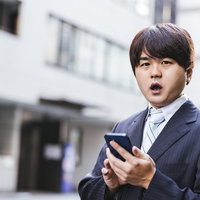 アポの約束をすっぽかした男性がスマートフォンで驚くの写真