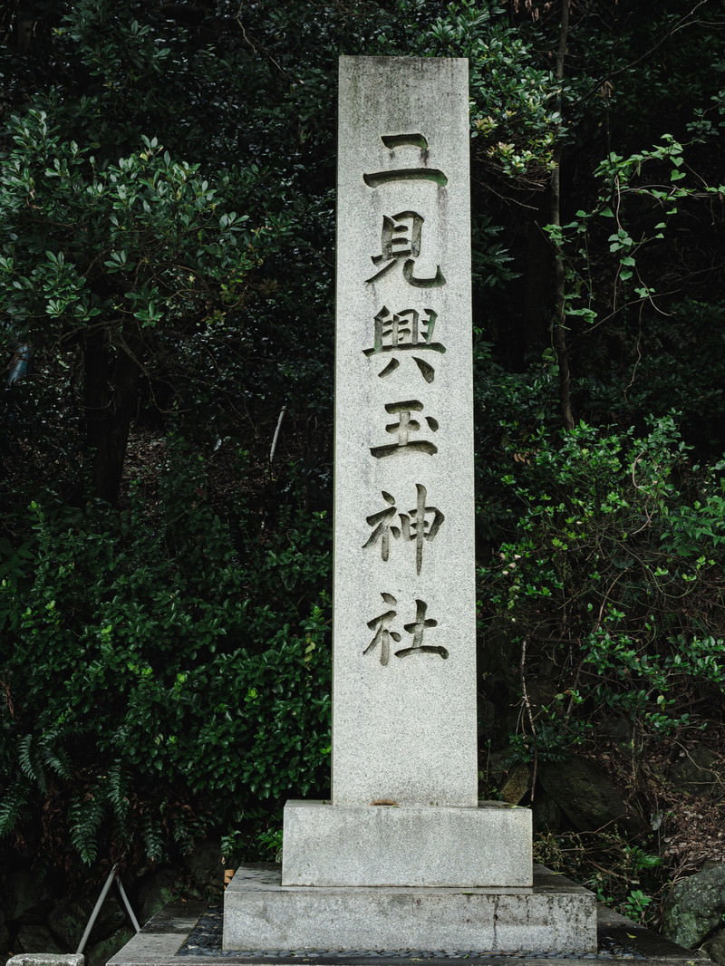 緑の自然に囲まれた二見玉輿神社入り口の白い石碑