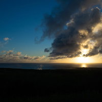 摺鉢山と千鳥ヶ浜の向うに見える夕陽に輝く雲の写真