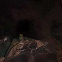 ドラム缶壕入口の地蔵と銃身の写真