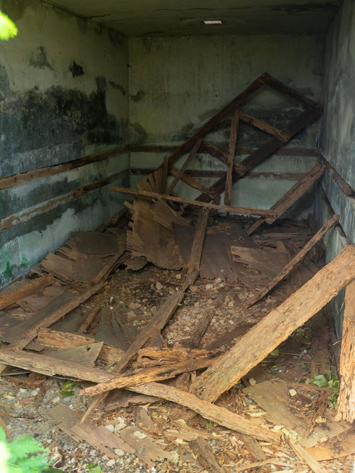 木片がバラバラと散らばるコンクリート建造物内部