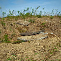 ▲荒地の中に石を積み上げた小さな煙突状の構造物の写真