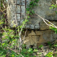 岩壁と錆びた鉄格子のある廃墟跡の写真