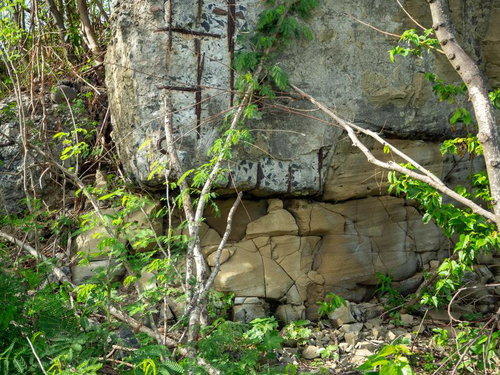 岩壁と錆びた鉄格子のある廃墟跡