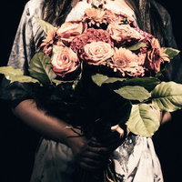 不吉な薔薇の花束を持つ女性の写真