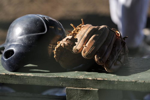 ベンチに置かれた野球ヘルメットとグローブ