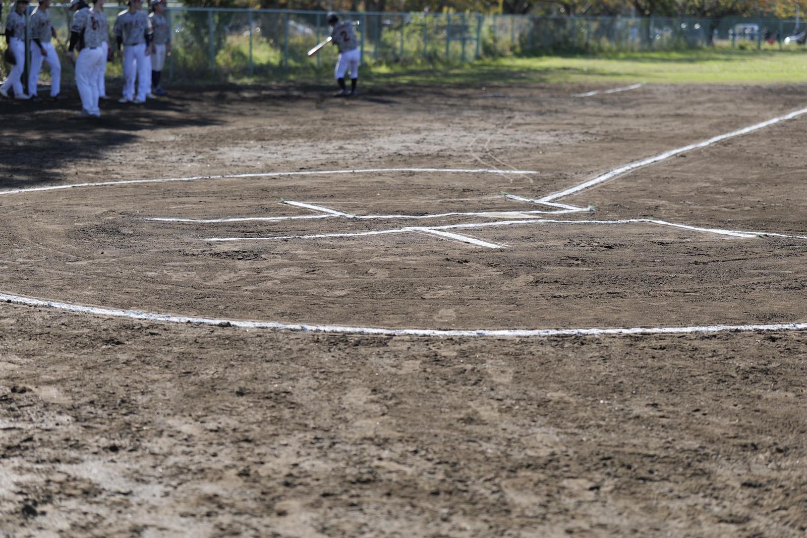Home plate area with white lines on dirt baseball infield