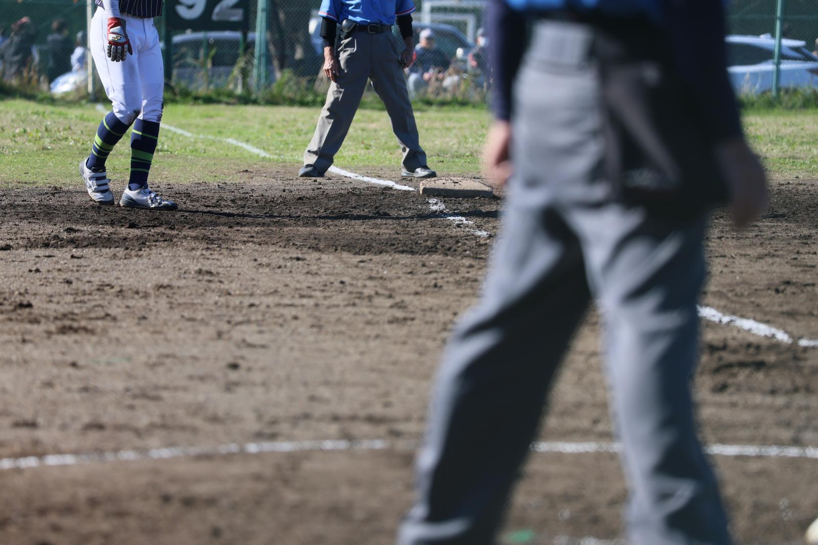 Umpire and players on a dirt baseball field
