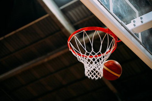 バスケットボールのリングを通るボールがシュート決定する瞬間