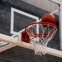 ゴールに吸い込まれるバスケットボール、シュートシーンの迫力の写真