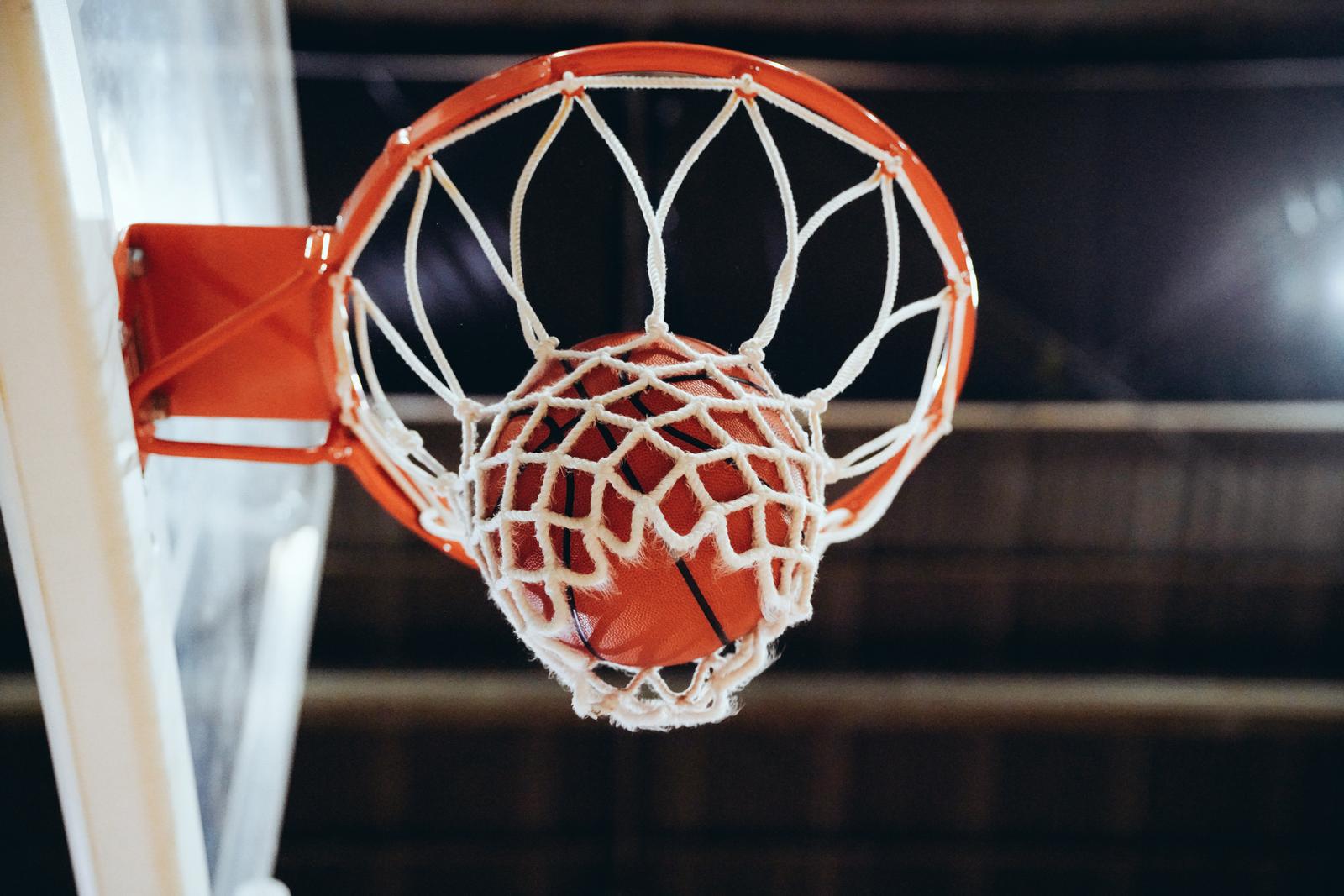 バスケットボールがリングを通ってネットに落ちていく瞬間