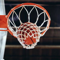 バスケットボールがリングを通過してネットに吸い込まれるシュート決定の瞬間の写真