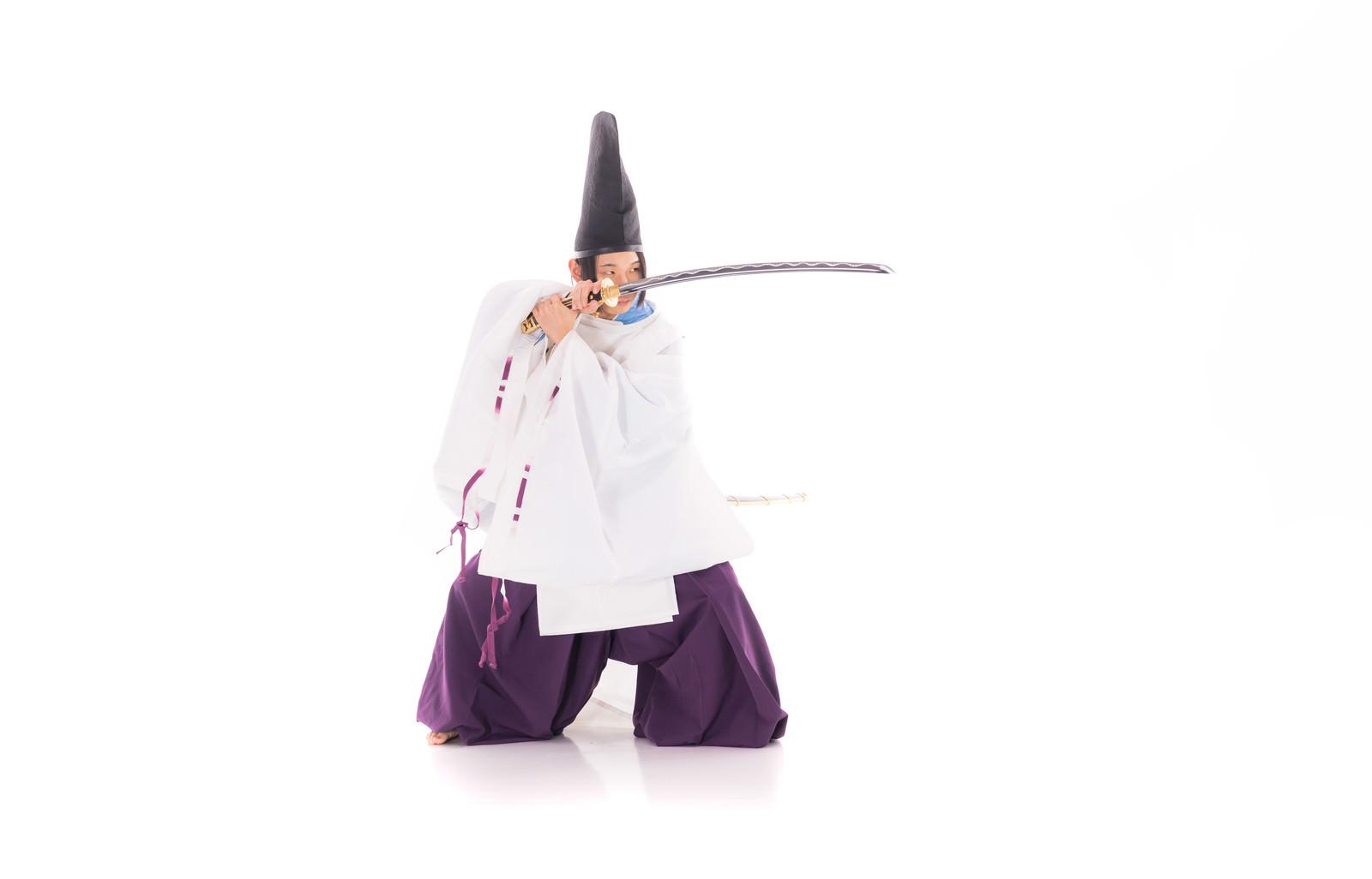 A samurai in white kariginu and purple hakama holding a mōbachi-gata tachi